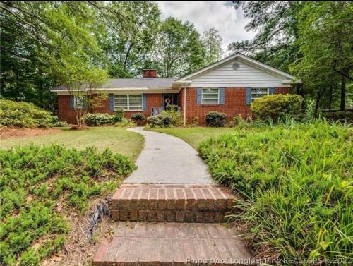 a brick house with a brick path in front of it at Central located large home on quiet wooded street in Lumberton