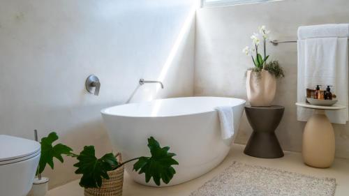 a bathroom with a large white tub and a toilet at Salt and Sand in Wilderness