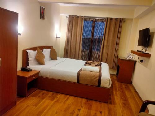 a hotel room with a bed and a window at Parasol Norling Hotel & Spa in Jāmb