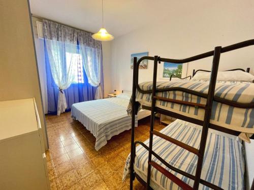 a bedroom with two bunk beds and a window at Beachside flat with shared pool in Porto Santa Margherita di Caorle