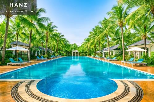 a pool at the resort with palm trees at S79 Phu Van Aires Beach Bungalow in Phu Quoc