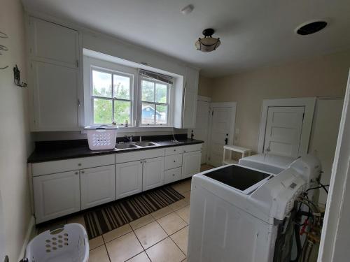 a kitchen with white cabinets and a sink and a window at Beautiful historic home with southern charm in Lumberton
