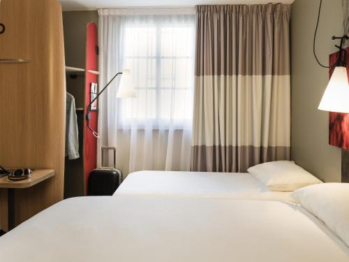 a hotel room with two beds and a window at ibis Saint Germain en Laye Centre in Saint-Germain-en-Laye