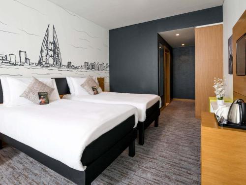 a hotel room with two large beds in it at ibis Styles Manama Diplomatic Area in Manama