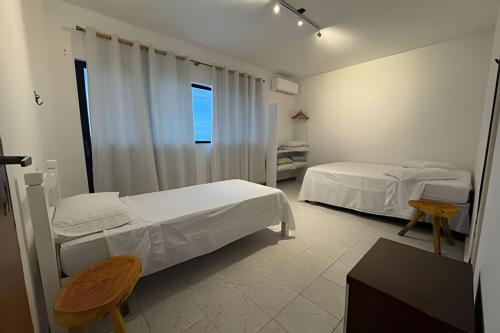 Giường trong phòng chung tại Cobertura Duplex com PISCINA PRIVATIVA de frente para o MAR 5 quartos até 14 pessoas