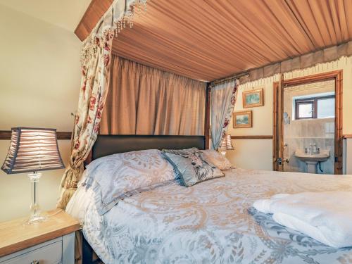 a bedroom with a bed with a canopy at The Stables - Uk30946 in Barthomley