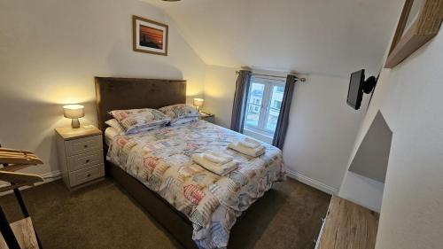 a bedroom with a bed with towels on it at Pepperpot in Portreath