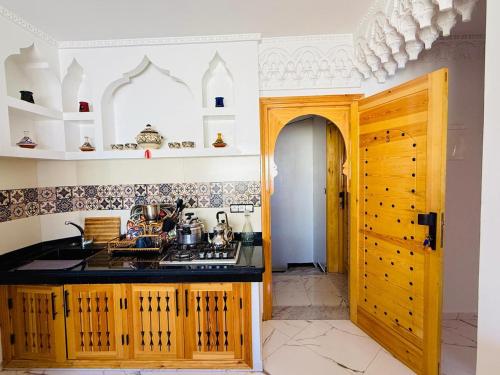 a kitchen with a sink and a stove top oven at Oualidia Holiday Apartment 3 in Oualidia