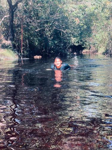 a young boy swimming in a river at Sítio Estrela da Manhã Hospedagem e Lazer in Palmeiras