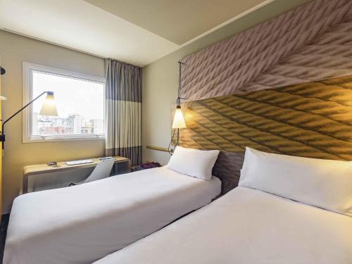 a hotel room with two beds and a window at ibis Sao Paulo Ibirapuera in Sao Paulo