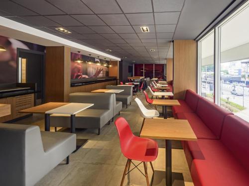 a restaurant with couches and tables and chairs at ibis Sao Paulo Ibirapuera in Sao Paulo
