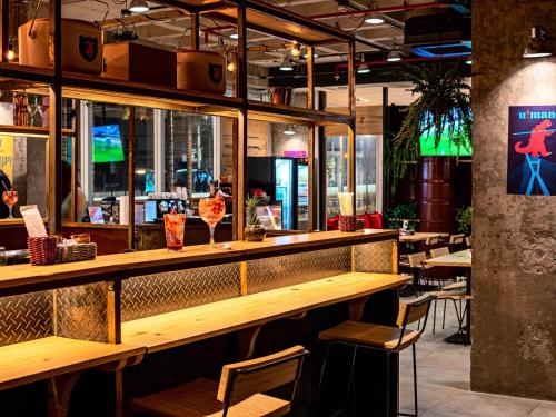 a bar in a restaurant with tables and chairs at ibis Sao Paulo Ibirapuera in Sao Paulo