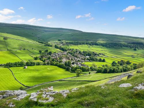 an aerial view of a small town in a green field at The Old School in Kettlewell