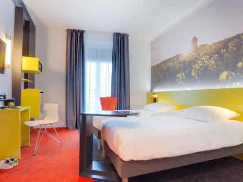 a bedroom with a large bed and a desk at ibis Styles Nantes Centre Gare in Nantes