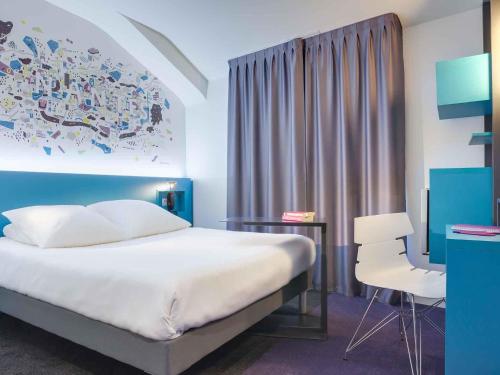 a bedroom with a bed and a desk and a chair at ibis Styles Nantes Centre Gare in Nantes