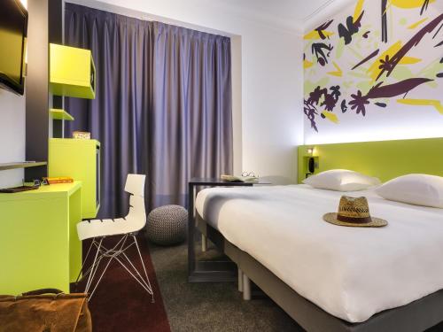 a hotel room with a large bed and a chair at ibis Styles Nantes Centre Gare in Nantes