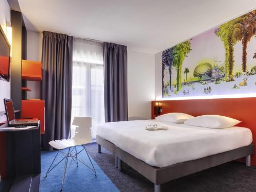 a hotel room with a large bed and a desk at ibis Styles Nantes Centre Gare in Nantes