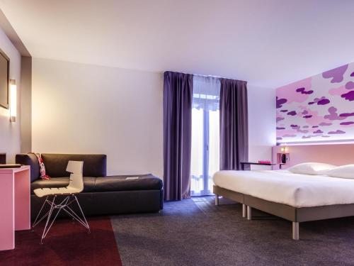 a hotel room with a bed and a couch at ibis Styles Nantes Centre Gare in Nantes