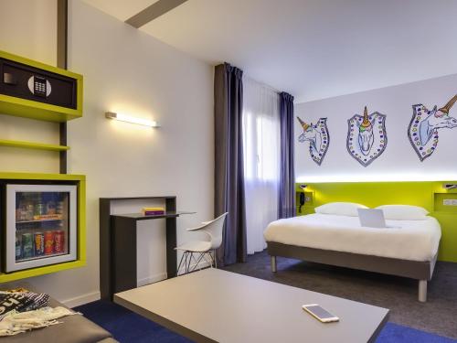 a hotel room with a bed and a desk at ibis Styles Nantes Centre Gare in Nantes