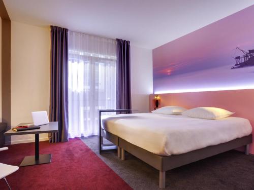 a hotel room with a large bed and a window at ibis Styles Nantes Centre Gare in Nantes