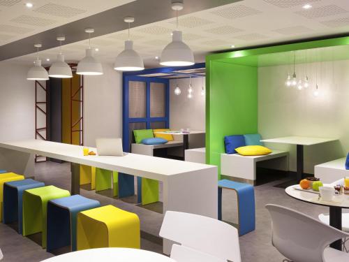 a brightly colored cafeteria with tables and chairs at ibis Styles Nantes Centre Gare in Nantes