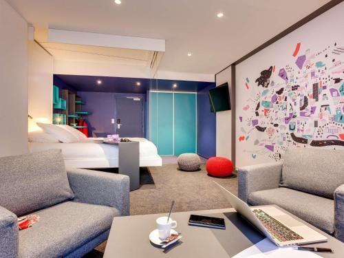 a room with a bed and a desk with a laptop at ibis Styles Nantes Centre Gare in Nantes