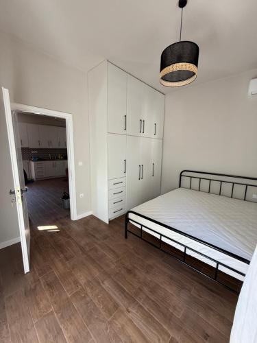 a bedroom with a bed and white cabinets and wooden floors at Grandpa's House in Pídhima