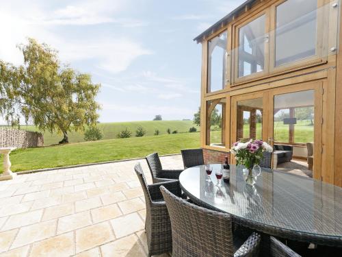 a patio with a glass table and chairs at The Row in Much Marcle