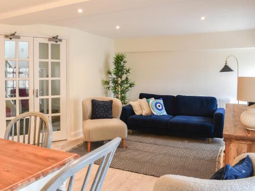 a living room with a blue couch and a chair at The Sloop in Swanage