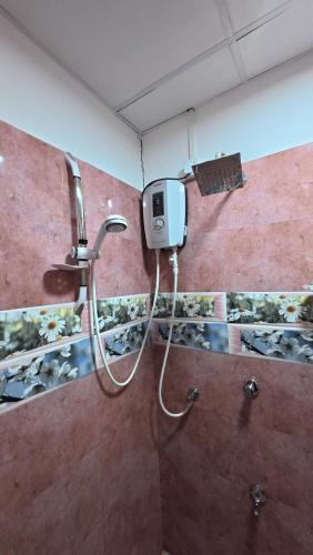 a shower in a bathroom with a soap dispenser on the wall at Meegahapokuna Resort in Anuradhapura