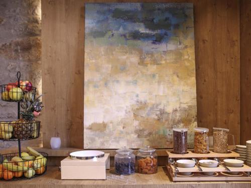 a table topped with jars and plates of food at Novotel Saint Brieuc Centre Gare in Saint-Brieuc