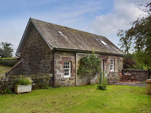 an old stone house with a grass yard at The Old Stables At Westerton in Crieff