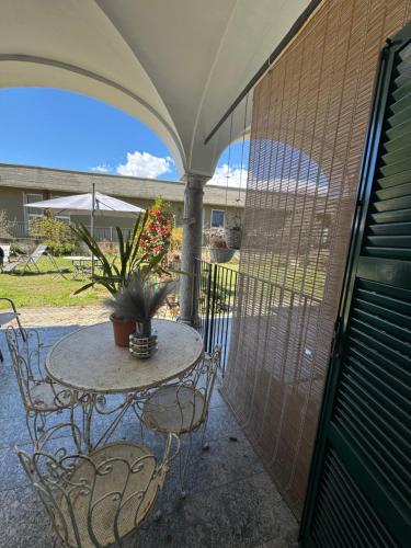 a patio with a table and chairs and an umbrella at Cà du lac in Dervio