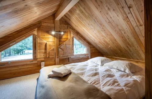 a large bed in a room with a wooden ceiling at Huttopia Barcelona Pirineos in Guardiola de Berguedà