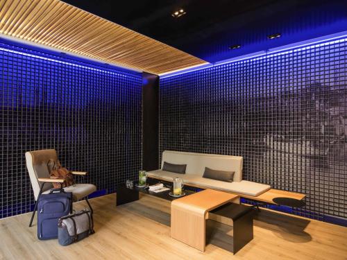 a room with a couch and a table and blue lights at Ibis Styles Heraklion Central in Heraklio Town