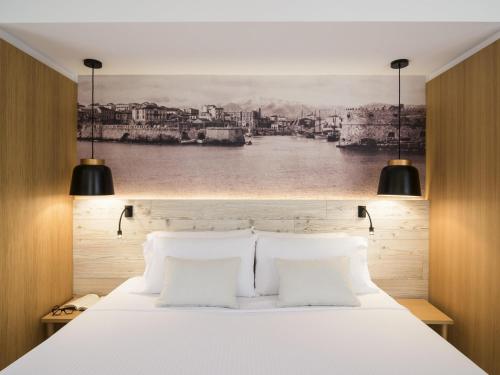 a bedroom with a white bed with two pillows at Ibis Styles Heraklion Central in Heraklio Town