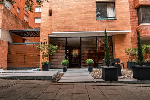 a brick building with a entrance with potted plants at 84 DC Bogotá By OxoHotel in Bogotá