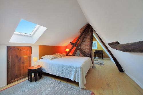 a attic bedroom with a bed and a skylight at Mouchette - Avec grand jardin in Créquy
