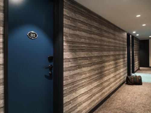 a wooden wall in a hallway with a door at ibis Styles Laval Centre Gare in Laval