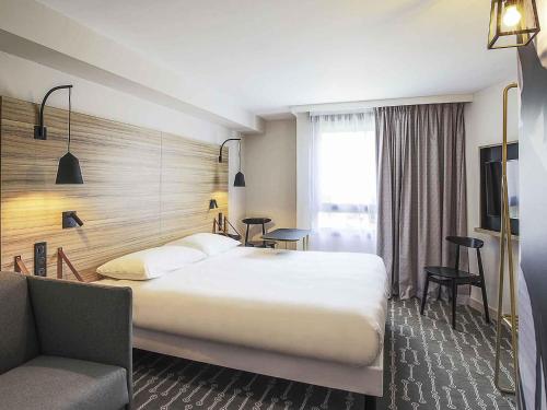 a hotel room with a large bed and a desk at ibis Styles Laval Centre Gare in Laval
