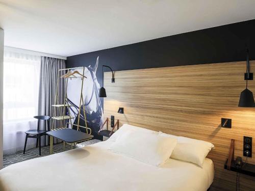 a hotel room with a bed and a chair at ibis Styles Laval Centre Gare in Laval