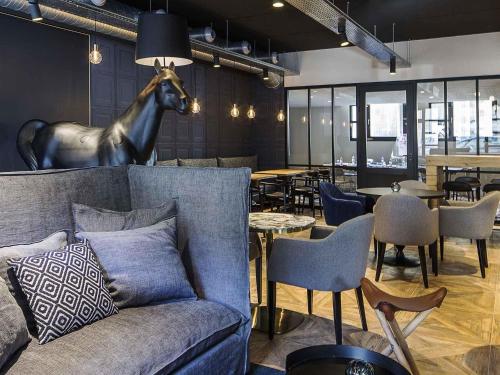 a living room with a couch and a horse statue on the wall at ibis Styles Laval Centre Gare in Laval
