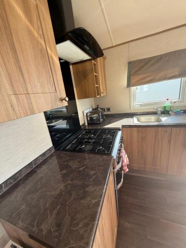 a kitchen with a stove and a counter top at Sandy Bay- No38 The Waterfront in North Seaton
