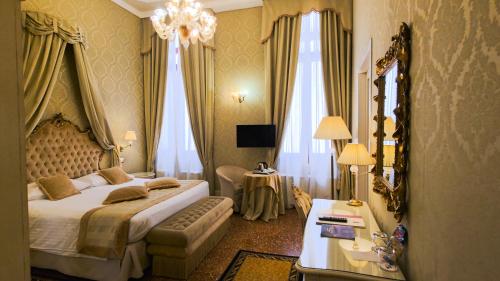 a hotel room with a large bed and a table at Hotel Al Duca Di Venezia in Venice