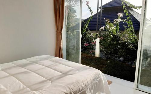 Salad Beach Bungalow - Sunset Seaview 2 bedroom في سالاد بيتش: سرير أبيض في غرفة مع نافذة كبيرة