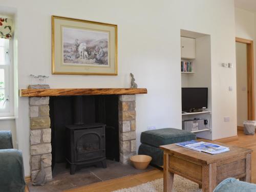 a living room with a fireplace and a table at Westerton Lodge - Srrh in Crieff