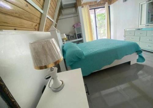 a bedroom with a bed and a table with a lamp at Villa Machepa 