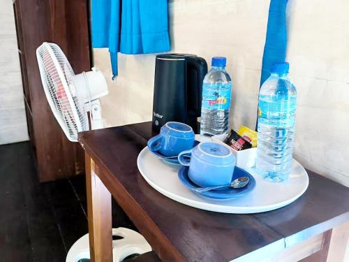 a table with two cups and two bottles of water at Oasi Bungalow Gili Air in Gili Islands