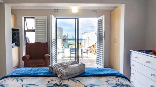 a bedroom with a bed with a view of a patio at The Sandcastle - Apartment in Villa in Witsand