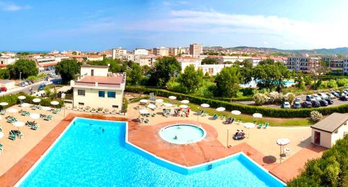 an overhead view of a pool with chairs and umbrellas at ISA - Apartments for 6 people, 2 bedrooms, in Residence Mirto And Corbezzolo with swimming pool in San Vincenzo in San Vincenzo